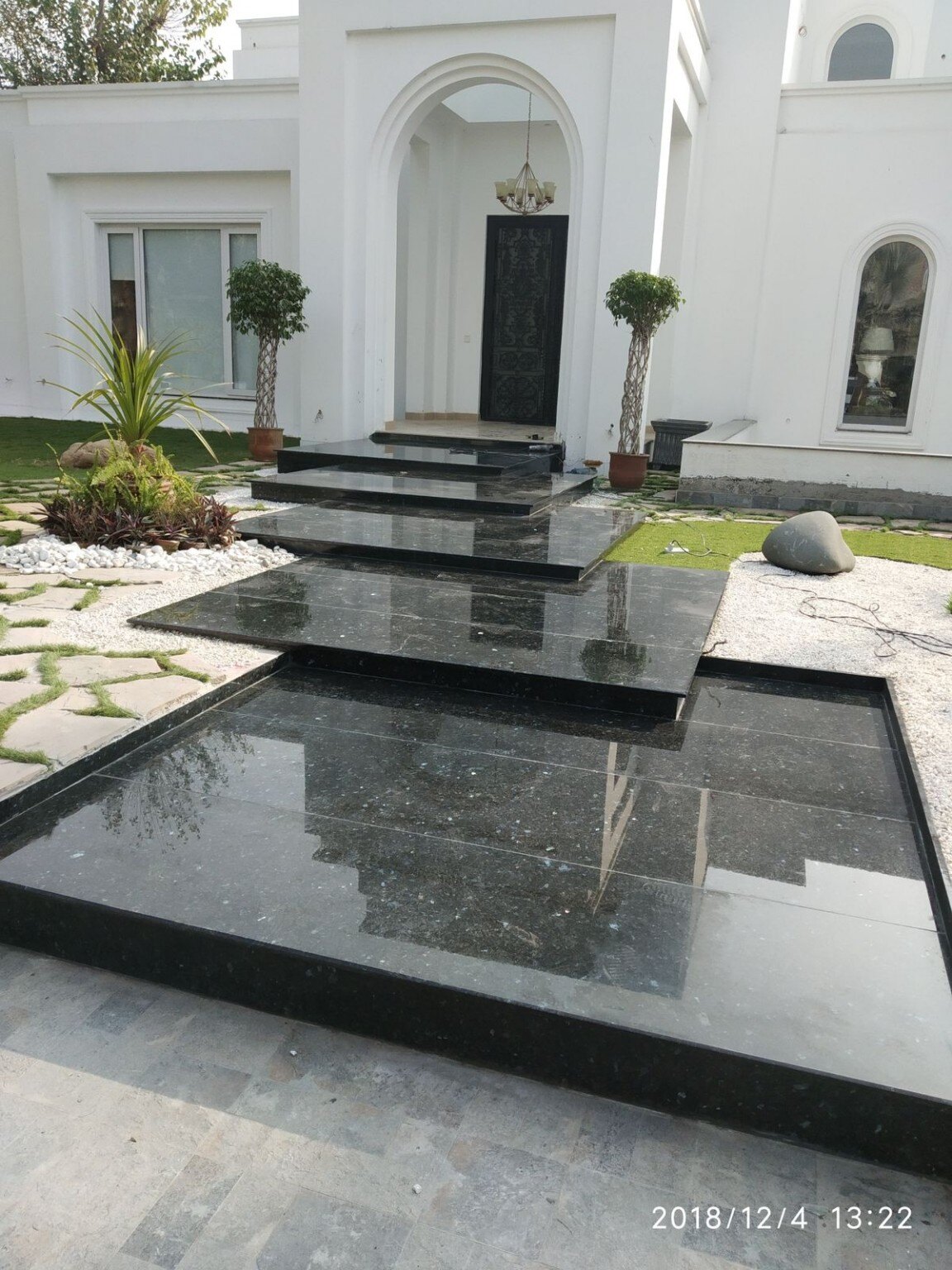 Completed New Eman stone residence with black reflecting pool